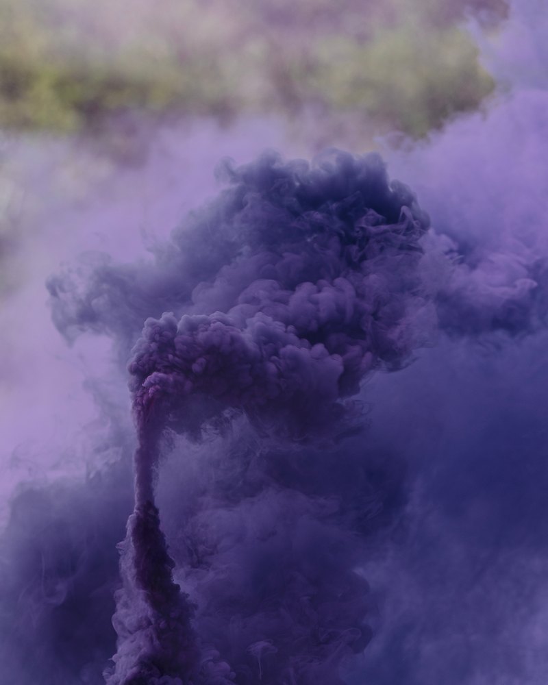 A thick column of purple smoke rising outdoors